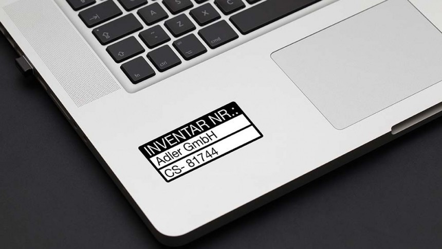 Etichetă argintie de inventar aplicată pe laptop