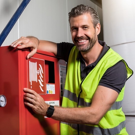 Lucrător în construcţii aplicând eticheta pentru hidrant