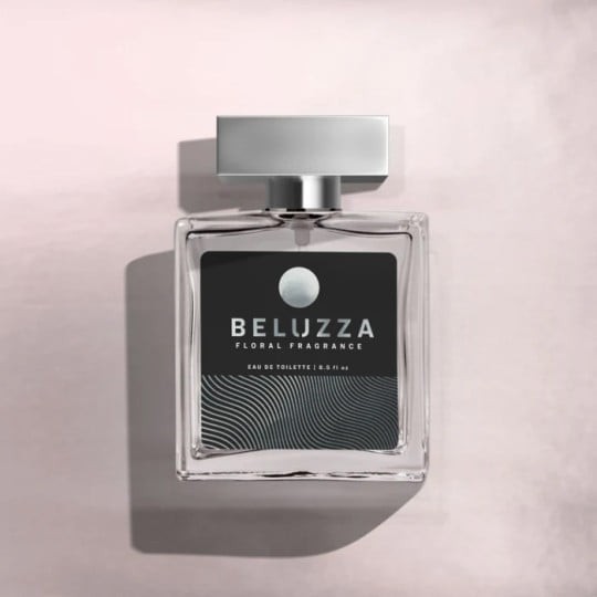 O sticlă de parfum pătrată, din sticlă, "Beluzza Floral Fragrance", cu un capac argintiu elegant. Eticheta neagră cu text alb este plasată pe un fundal roz pudrat.
