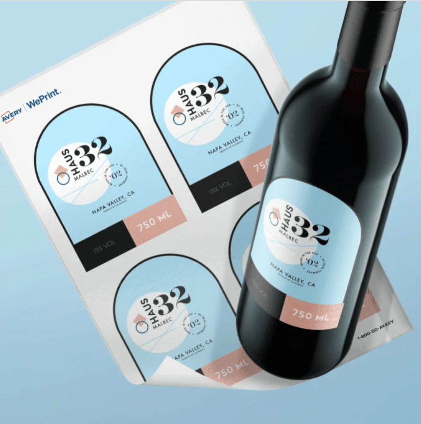 O coală cu etichete imprimate pentru vin "HAUS 332" aflată lângă o sticlă pe care a fost deja aplicată una dintre etichete, ilustrând procesul de aplicare.