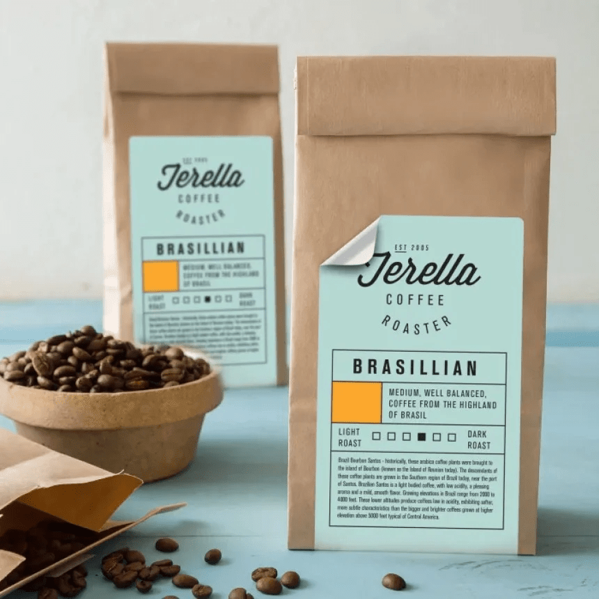 Două pungi de cafea "Jerella Coffee Roaster" cu o etichetă care indică originea braziliană a boabelor. Alături se află un bol cu boabe de cafea prăjite.
