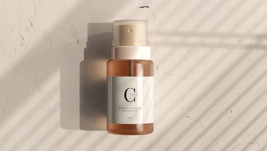 O sticluță mică, semitransparentă, cu pulverizator, care conține ser pentru față. O etichetă albă, minimalistă, cu o literă mare "G" și textul "Serum Visage". Produsul este așezat pe o suprafață deschisă, din beton, luminată de soare, care creează umbra unei frunze de palmier.