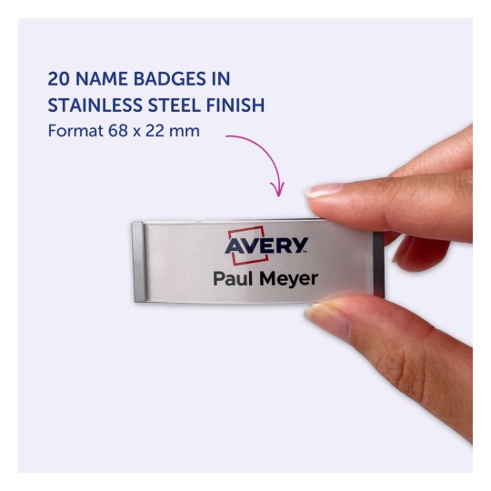 O imagine care arată un ecuson cu nume din oțel inoxidabil cu textul 'Avery Paul Meyer'. Ecusonul este ținut de mâna unei persoane. Fundalul este de culoare mov deschis, iar dimensiunile ecusonului sunt specificate ca 68 x 22 mm.