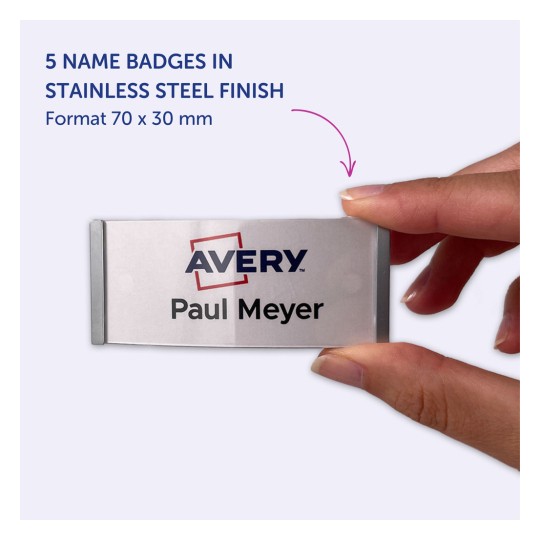 Imaginea arată o persoană care ține un ecuson cu numele 'Avery Paul Meyer'. Indică faptul că produsul este un set de cinci ecusoane cu un finisaj din oțel inoxidabil, având dimensiunile de 70 x 30 mm.