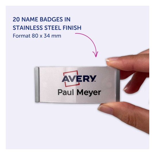 Imaginea arată o mână care ține un ecuson cu numele 'Paul Meyer' și logo-ul 'Avery'. Ecusonul are un finisaj din oțel inoxidabil, măsurând 80 x 34 mm, iar în acest format sunt listate 20 de ecusoane.