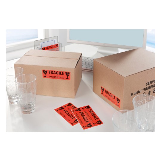 Imaginea arată două cutii de carton etichetate 'FRAGIL' cu pahare lângă ele pe un birou.