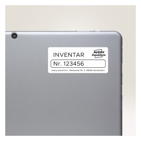 Imaginea arată spatele unei tablete sau al unui laptop cu o etichetă pe el. Eticheta are inscripția 'INVENTAR Nr. 123456', indicând informații de inventar, și prezintă numele de marcă 'Avery Zweckform' împreună cu o adresă.