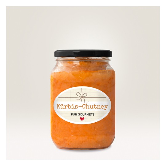 Imaginea arată un borcan de Kürbis-Chutney cu o etichetă decorativă. Chutney-ul are o culoare portocalie vibrantă, iar borcanul are un capac negru. Eticheta prezintă textul 'Kürbis-Chutney für Gourmets' pe un fundal deschis la culoare.