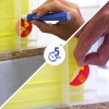 Hand applying and peeling a round red label from a clear plastic dispenser of yellow cards