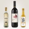 Imaginea prezintă trei sticle: o sticlă de oțet balsamic de mere, o sticlă de vin roșu etichetată 'Night Owl' și o sticlă de lichior de cremă. Acestea sunt aranjate pe un fundal deschis.