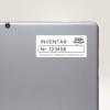 Imaginea arată spatele unei tablete sau al unui laptop cu o etichetă pe el. Eticheta are inscripția 'INVENTAR Nr. 123456', indicând informații de inventar, și prezintă numele de marcă 'Avery Zweckform' împreună cu o adresă.