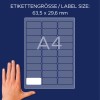 Imaginea arată o coală de etichete cu dimensiunile 63,5 x 29,6 mm, proiectată pentru formatul A4. O mână este așezată lângă coală pentru referință.
